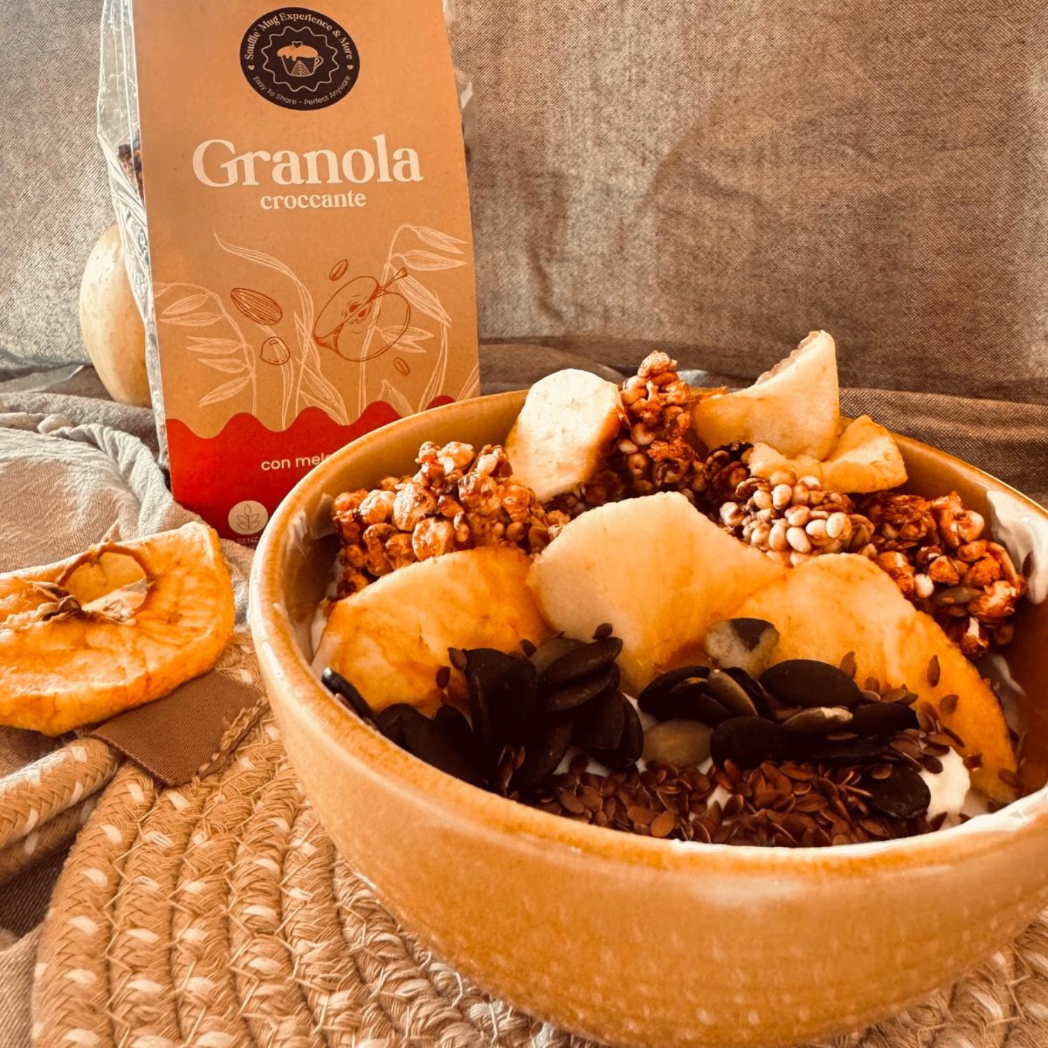 bowl con granola alle mele essicate sana e croccante, senza glutine con mirtilli e semi con yogurt bianco e sciroppo d'acero , un cucchiaino di crema alle nocciole