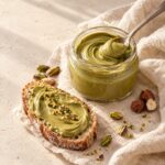 Crema al pistacchio in barattolo e spalmata su una fetta di pane