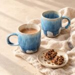 Due tazze artigianali blu con bevanda calda e granola